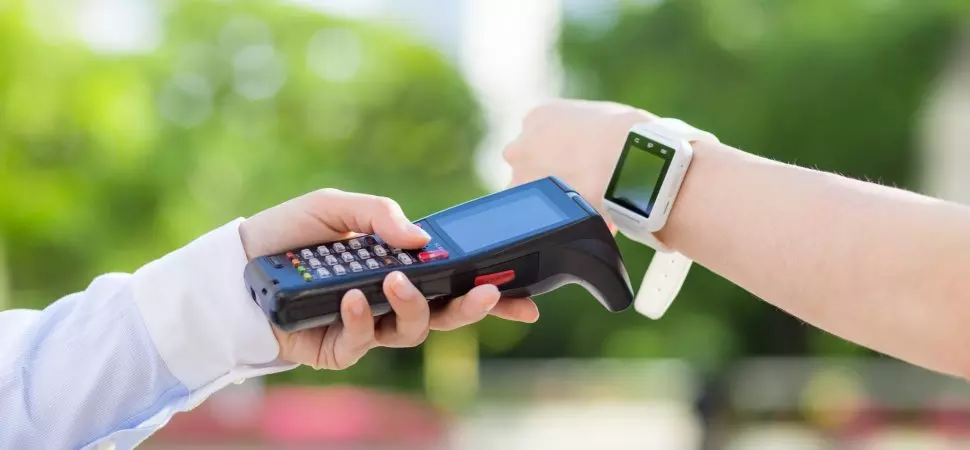 Health club member uses a smart watch for contactless payment with a POS system, ideal for fitness businesses.